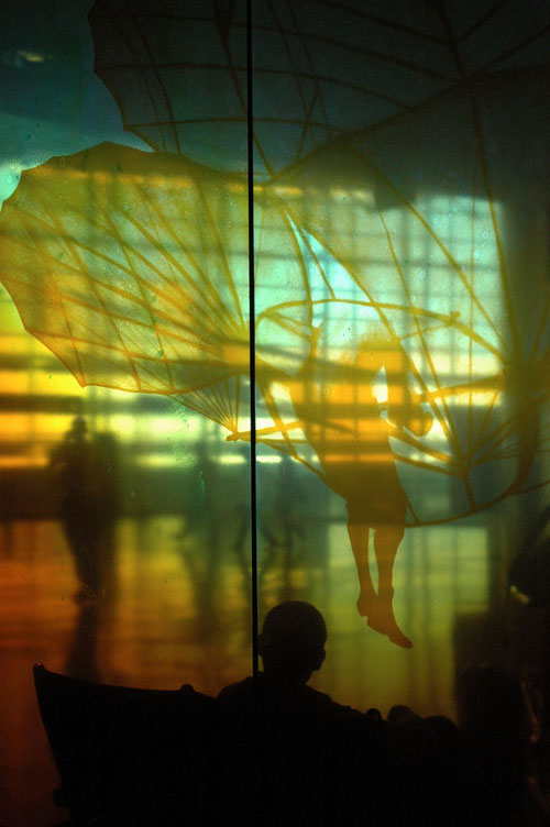 Time Landing, Seattle Abstract of man looking through glass art at Seattle airport