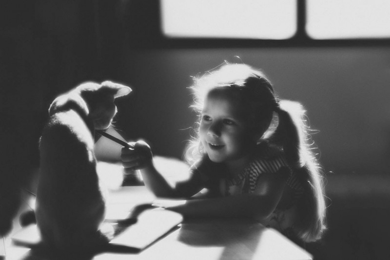 Young girl playing with a cat (shot with Lensbaby's Velvet 56 lens)