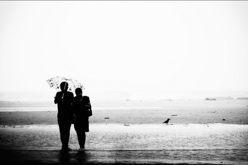 A couple walks the beach in Tamilnadu, India A couple walks the beach in Tamilnadu, India