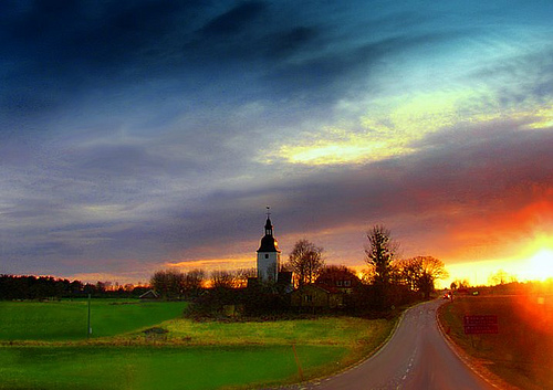 Sun sets behind the FÃ¤rentuna church on FÃ¤ringsÃ¶ in Sweden