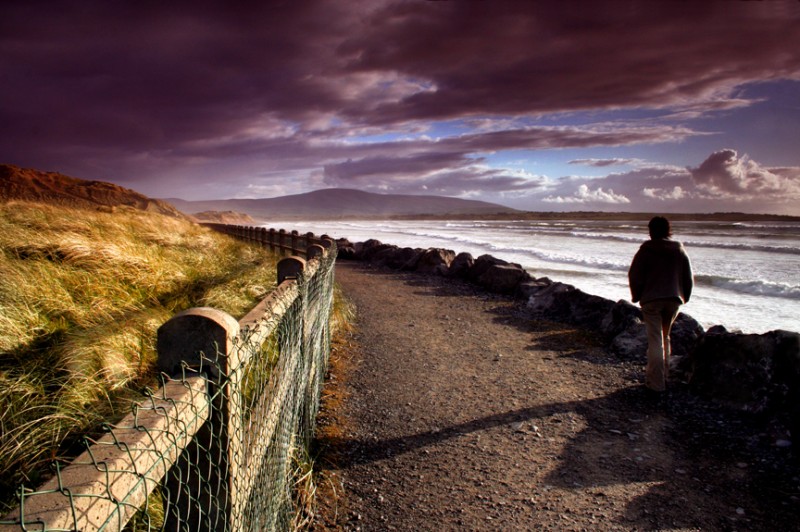 Woman hiking along shore in Sligo, Ireland