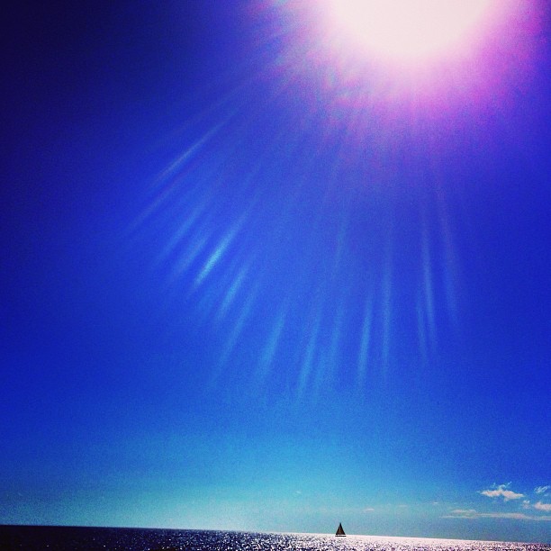 A lone sailboat on open water in Maui, Hawaii A lone sailboat on open water in Maui, Hawaii
