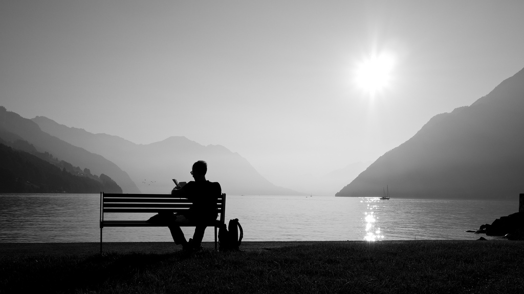 Man relaxing on a bench near a lake, Switzerland