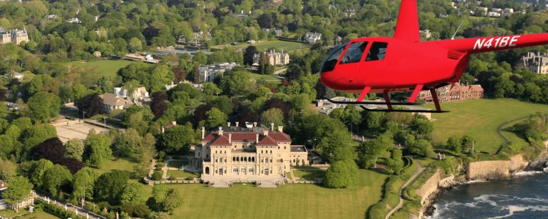 Red helicopter flying over the mansions of Newport, Rhode Island