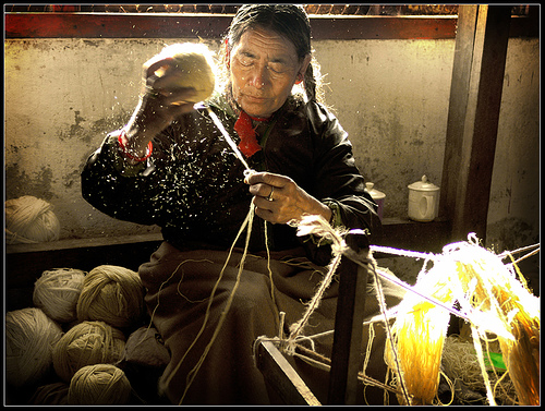 Old woman spinning wool at Tibetan Carpet Factory in South Sikkim, India