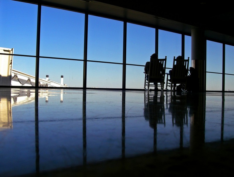 Two people relaxing in chairs at Boston's Logan Airport
