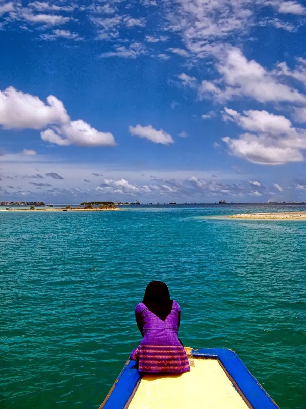 Self Revolution Girl sitting on end of dock staring at ocean