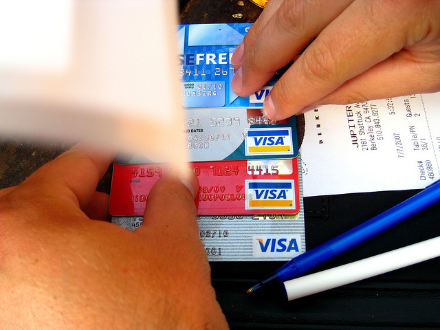 Hands holding stack of Visa credit cards