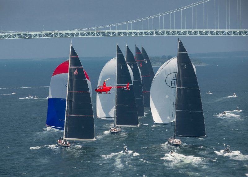 Red helicopter flying over sailboats in Newport, Rhode Island